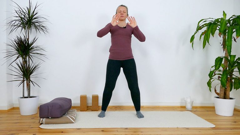 Frau macht Yogaübung im Wohnzimmer zwischen Zimmerpflanzen:
